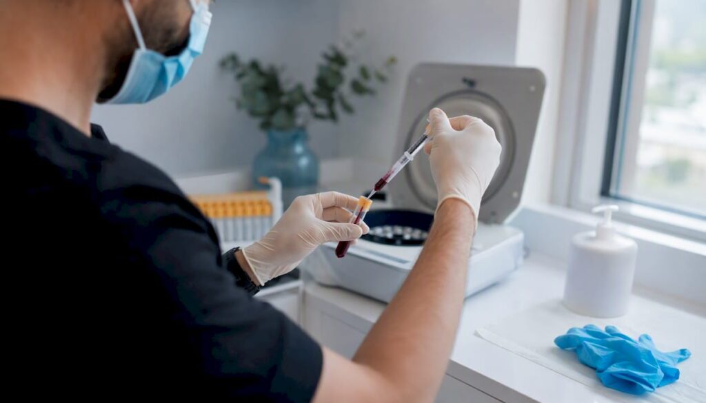 Manos preparando un tratamiento facial con PRP, manipulando la muestra de sangre y utilizando la centrífuga.