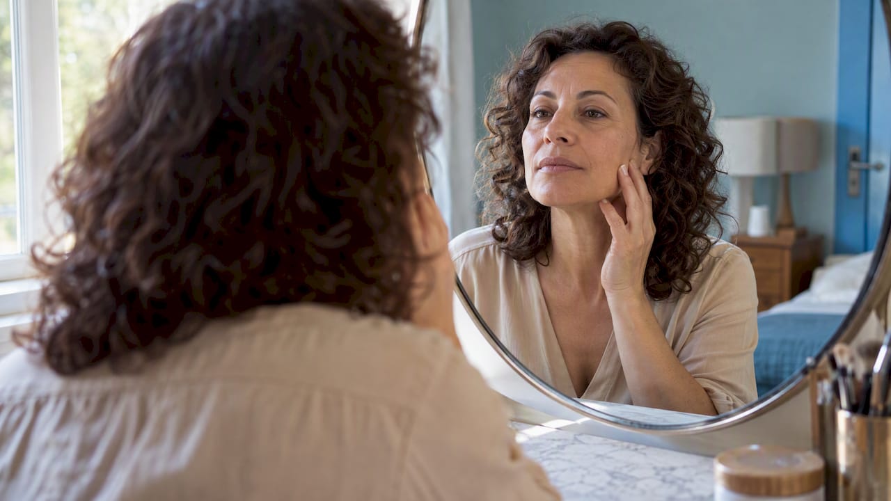 Mujer contempla su reflejo en el espejo