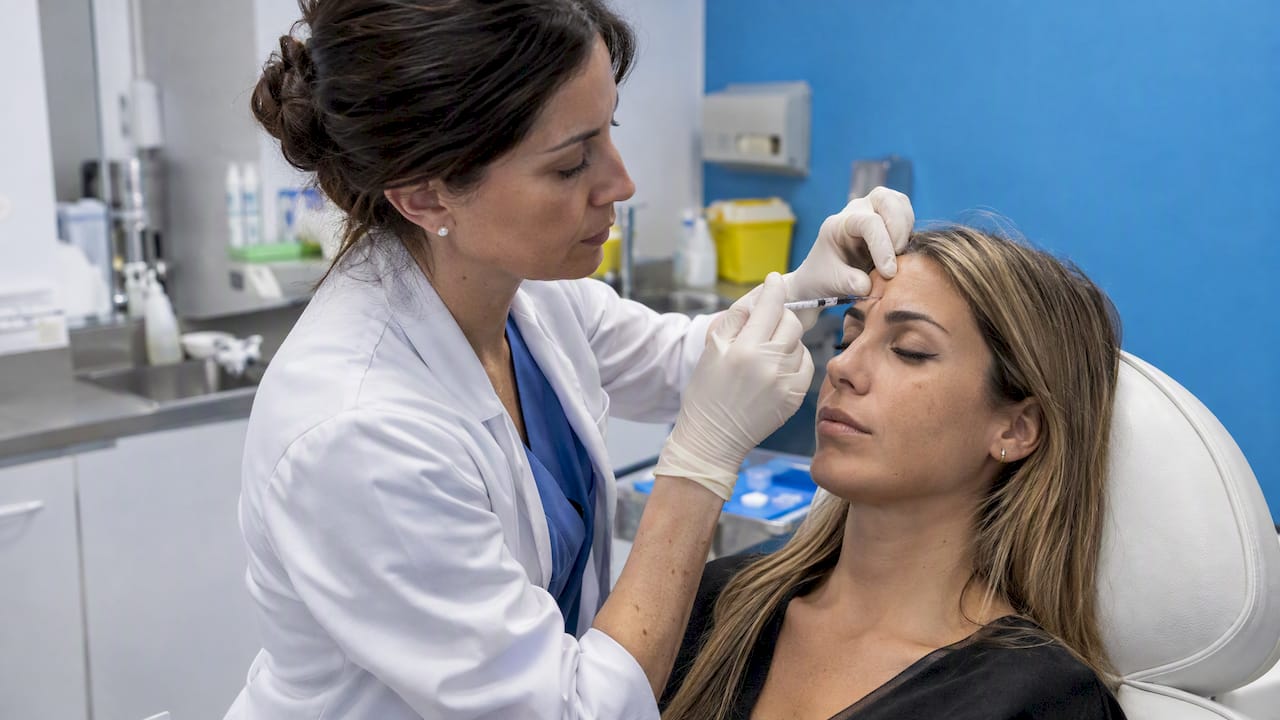 Doctora aplica toxina botulínica en el entrecejo